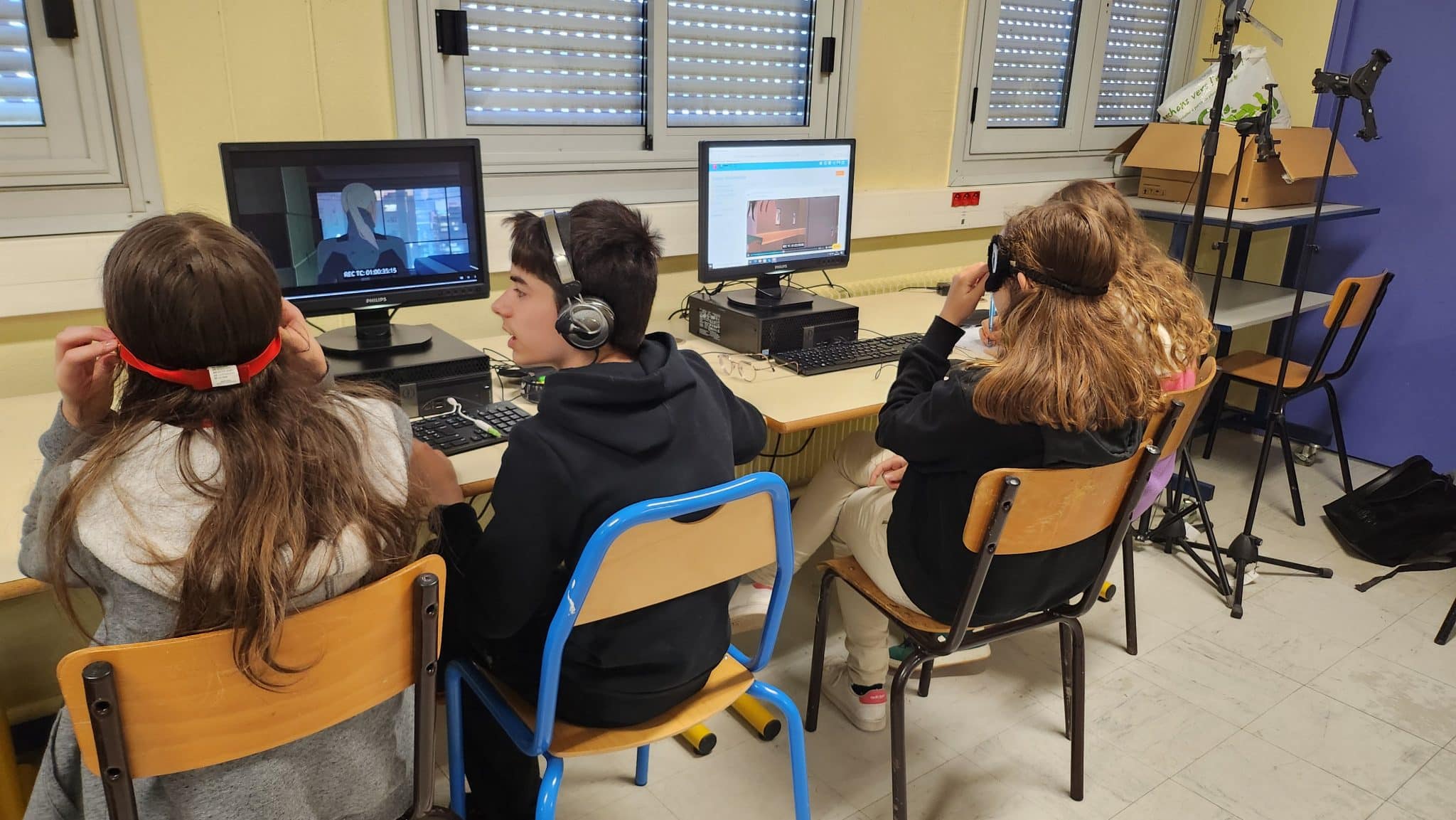 Photo de l'atelier : trois élèves sont assis face à deux écrans d'ordinateur, sur lesquels ils lisent des extraits du film Mars Express.